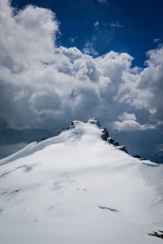 Summit of eleven-thousand-footer Mount Hector with stormclouds enveloping dark blue skies above me…