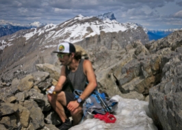 Eating a ProBar in the rock shelter (which offers mininal shelter) on top of Ha Ling Peak, 2408m, four hours and nine minutes after leaving downtown Canmore. Mighty Mount Temple is in the background at far left looking closer than it actually is.